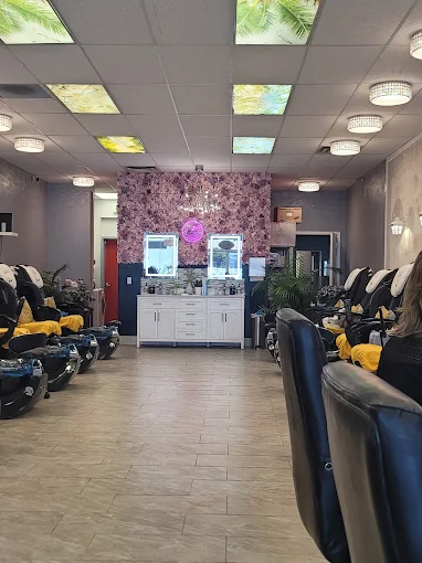 Back section of MY Nails & Spa featuring flower wall, vanity mirrors, and pedicure chairs