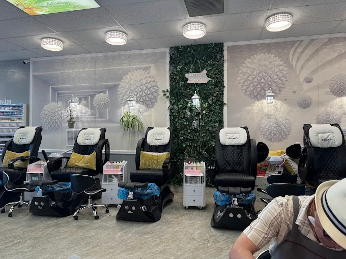Row of pedicure massage chairs at MY Nails & Spa with decorative greenery wall
