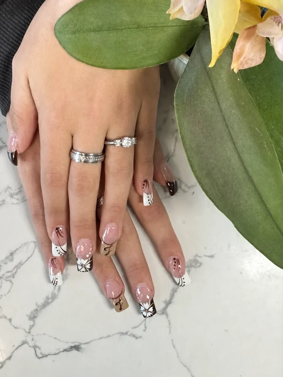 Neutral French tip nails with white floral line art