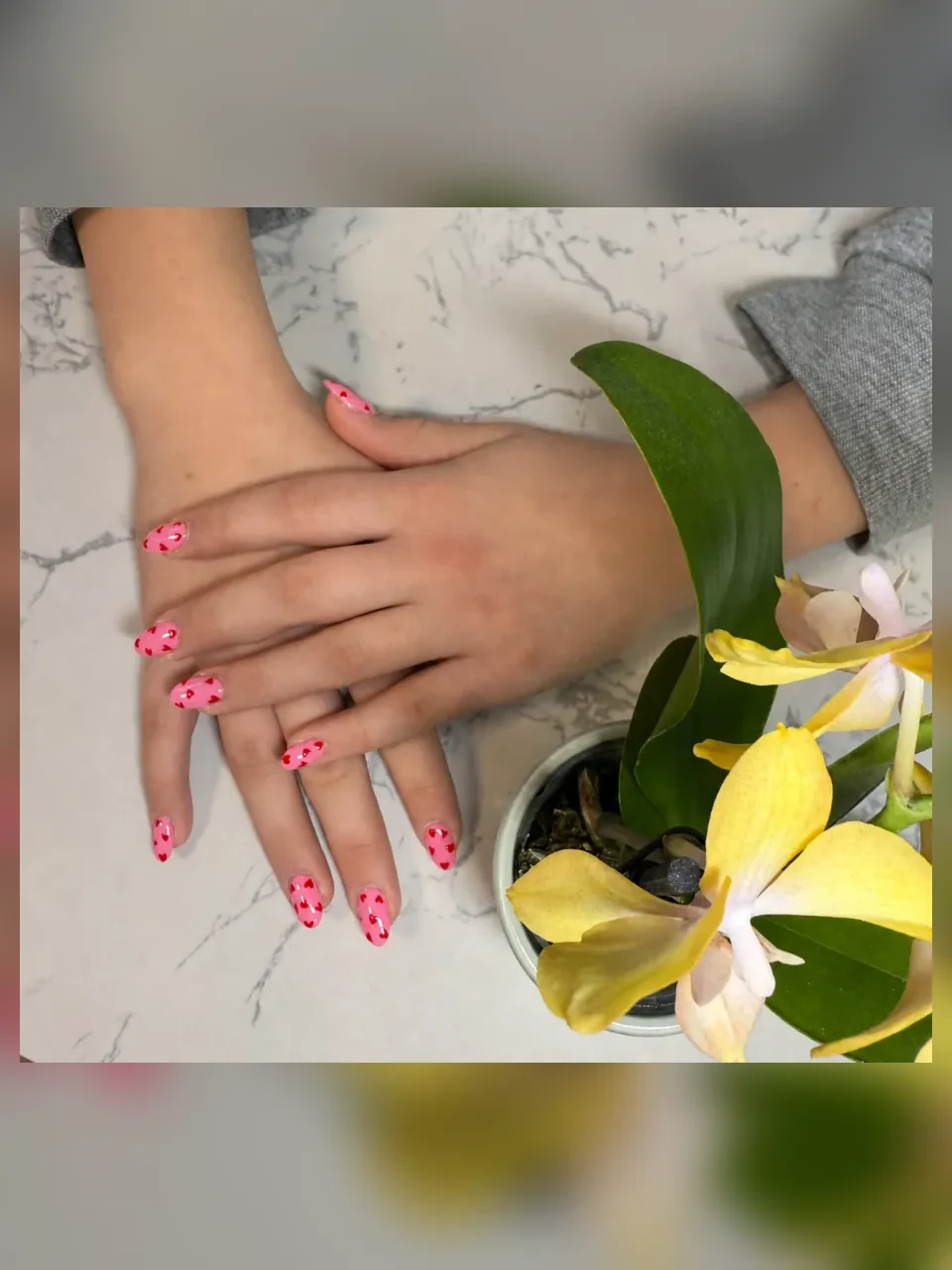 Pink almond nails decorated with red hearts